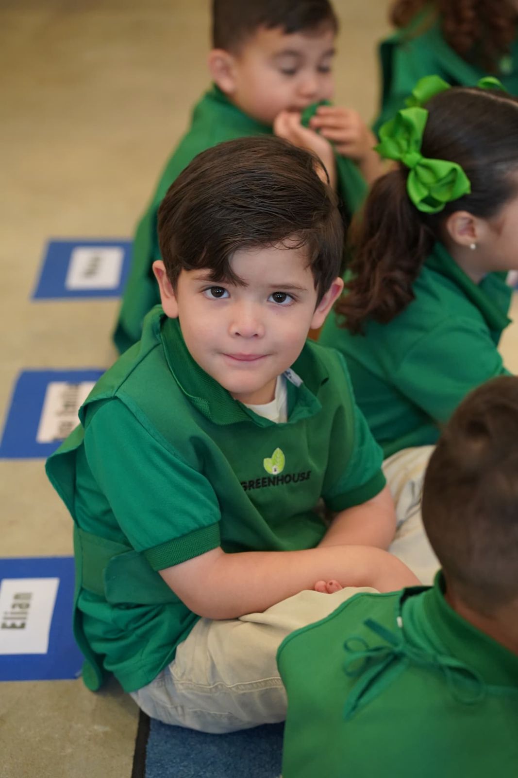 Grupo de niños con uniforme verde de Greenhouse durante la clase
