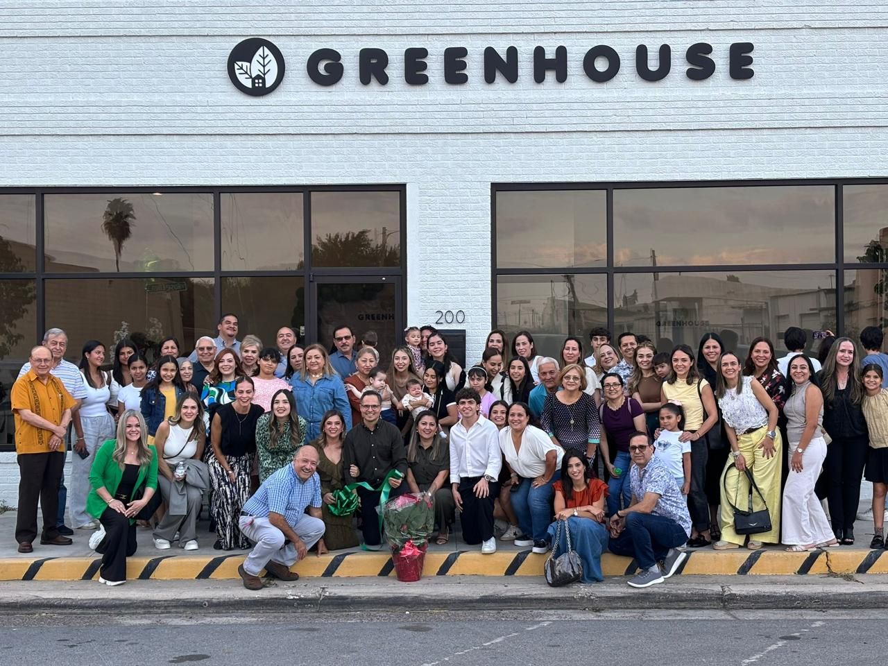Familias y equipo de Greenhouse Learning Center reunidos frente a la fachada en McAllen, Texas